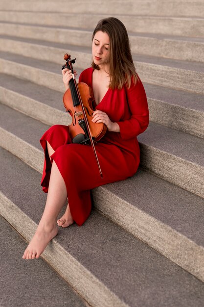 Violinist posing on steps with violin