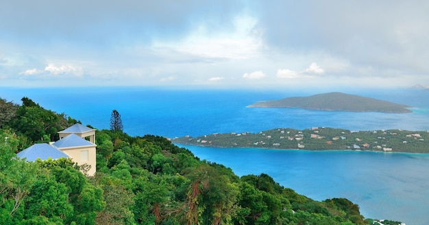 버진 아일랜드 세인트 토마스(Virgin Islands St Thomas)는 구름, 건물, 해변 해안선이 있는 탁 트인 산의 전망을 제공합니다.