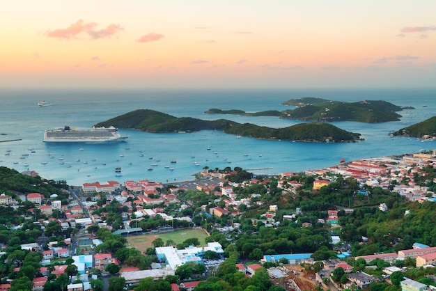 Foto gratuita alba di san tommaso delle isole vergini con nuvole colorate, edifici e costa della spiaggia.