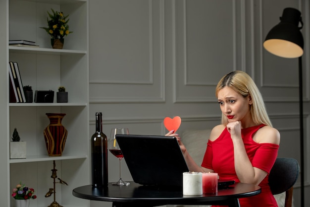 Virtual love cute blonde girl in red dress on distance date with wine upset on camera