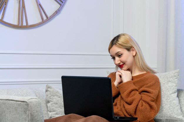 Virtual love cute young blonde girl in cozy sweater on computer distance date smiling lovely