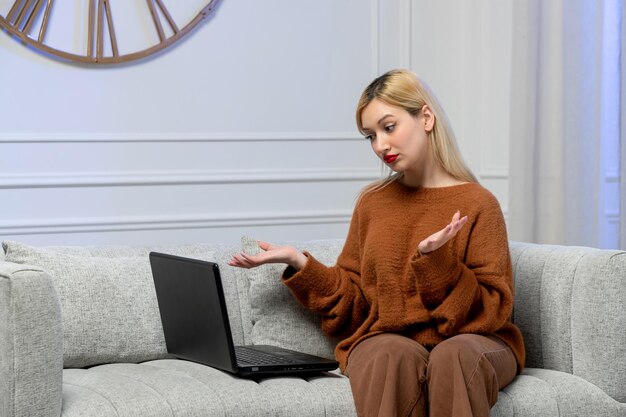 Виртуальная любовь симпатичная молодая блондинка в уютном свитере на дистанционном свидании с компьютером машет руками
