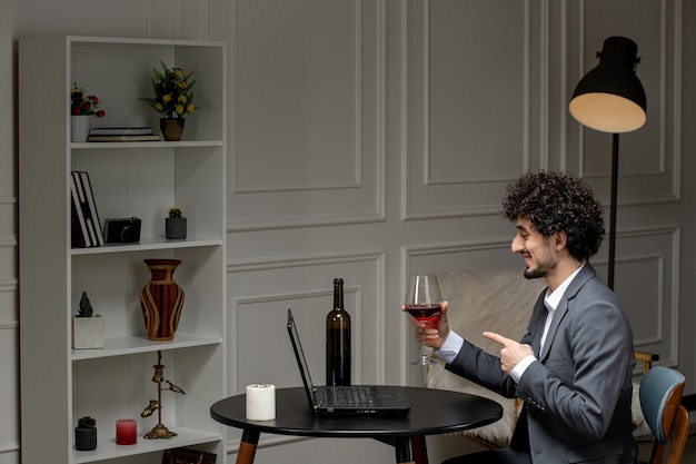 Virtual love handsome cute guy in suit with wine on a distance computer date drinking wine