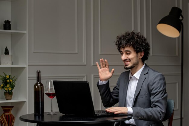 Virtual love handsome cute guy in suit with wine on a distance computer date saying goodbye