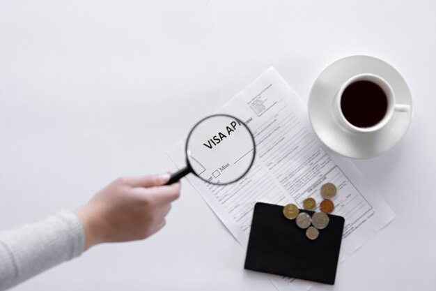 Visa application form, documents, magnifier and a cup of coffee on a white background, the concept of immigration, registration, copy space.