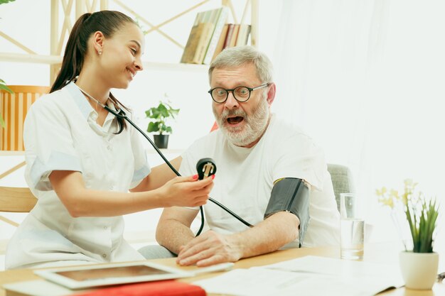 The visiting nurse or health visitor taking care of senior man