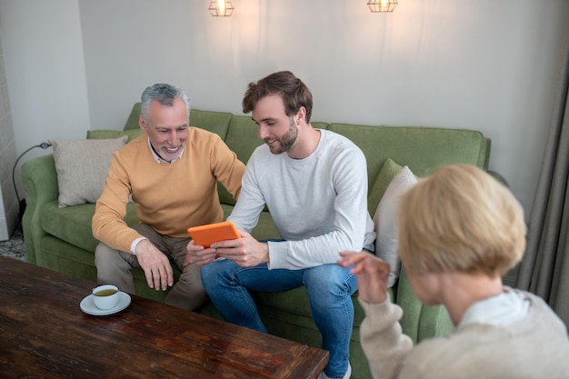 Visiting parents. Son visiting parents and showing new photos to them