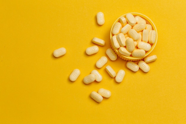 Бесплатное фото Таблетки витамина в на желтом фоне