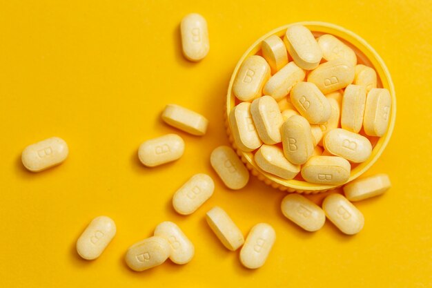 Таблетки витамина В на желтом фоне