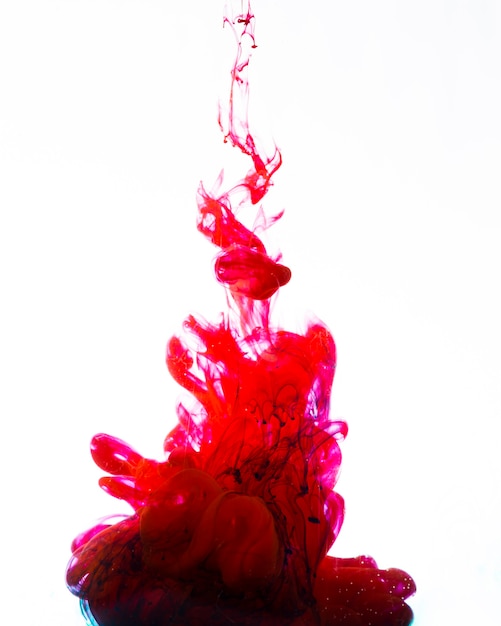 Яркие красные чернила, кружащиеся под водой