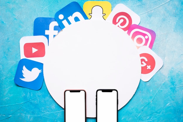 Vivid social media icons over the circular frame with two cellphone on blue wall
