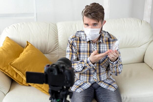 Vlogger recording video at home with hand sanitizer