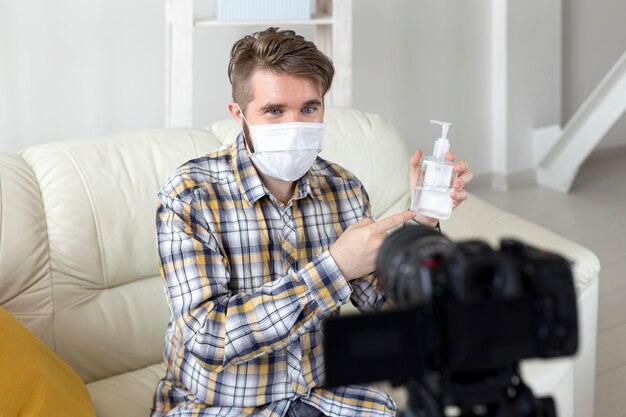 Vlogger recording video at home with hand sanitizer