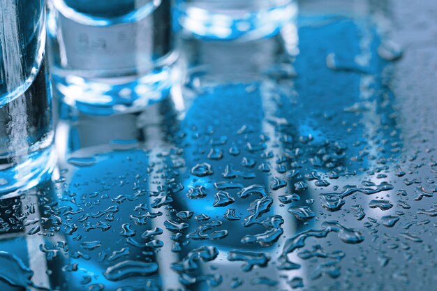 Vodka glass with ice on blue