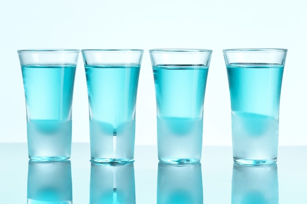 Vodka glass with ice on blue