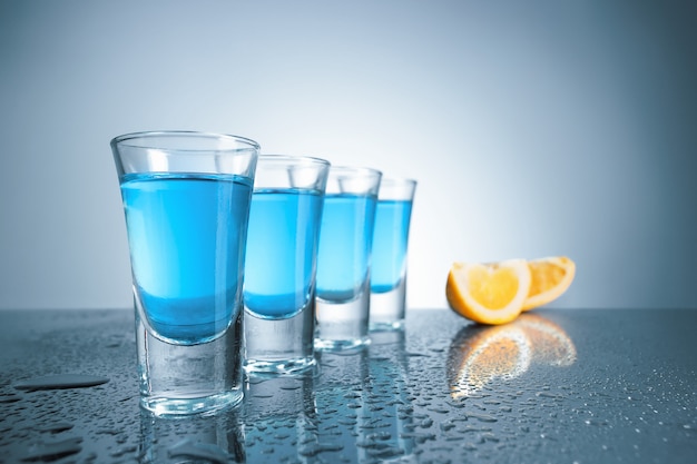 Vodka glass with ice on blue