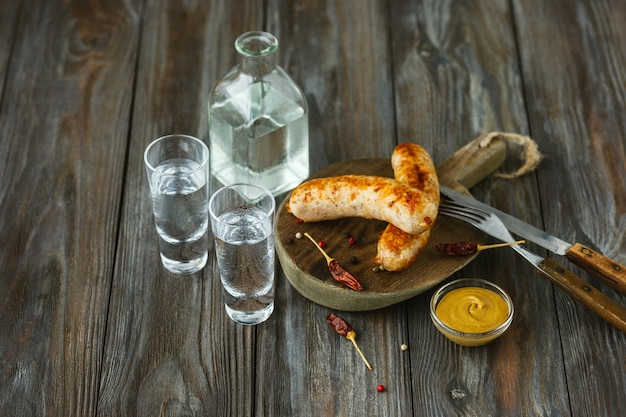 Vodka and traditional snack on wooden wall
