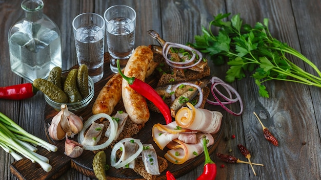 Vodka and traditional snack on wooden wall