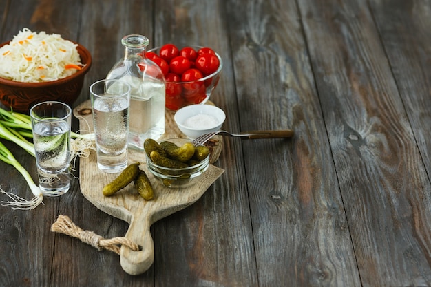 Vodka and traditional snacks on wooden floor