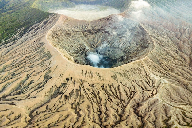 Кратер вулкана изгоняет дым