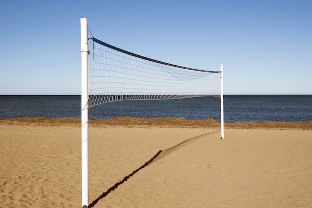 Foto gratuita rete da pallavolo nella spiaggia di sabbia durante il giorno