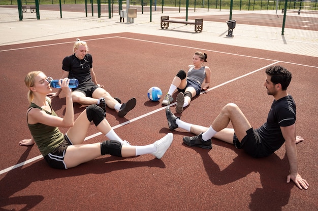 Free photo volleyball players resting after match