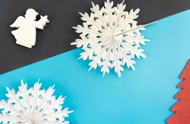 Free photo volumetric paper snowflakes on a colored background flat lay