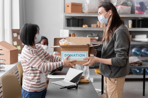 Volunteer collecting a donation box from another volunteer