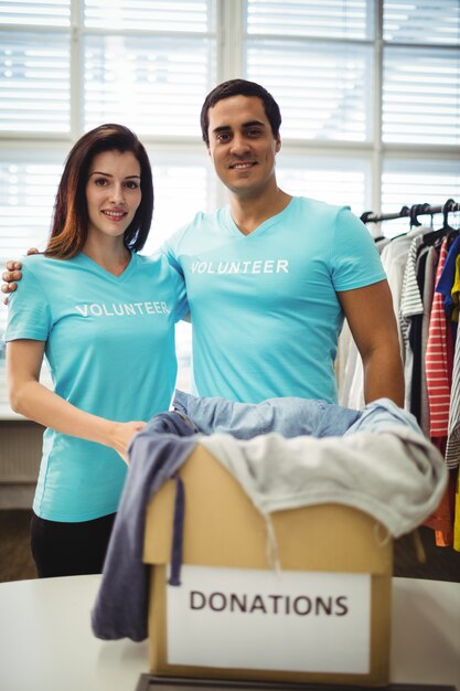 Volunteer couple standing with donation box