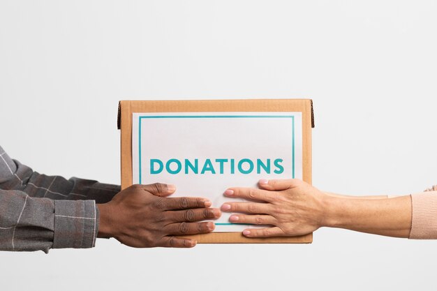 Волонтер передает коробку с пожертвованиями другому волонтеру