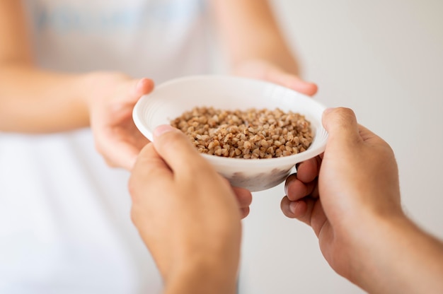 ボランティアが寄付された食料のボウルを貧しい人に渡す