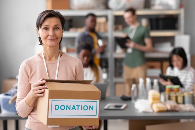 Волонтер помогает с ящиком для пожертвований