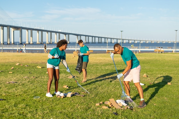 Volunteer team cleaning city grass from garbage