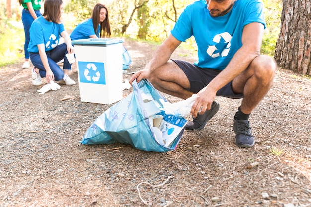 Volunteers collecting trash in forest 