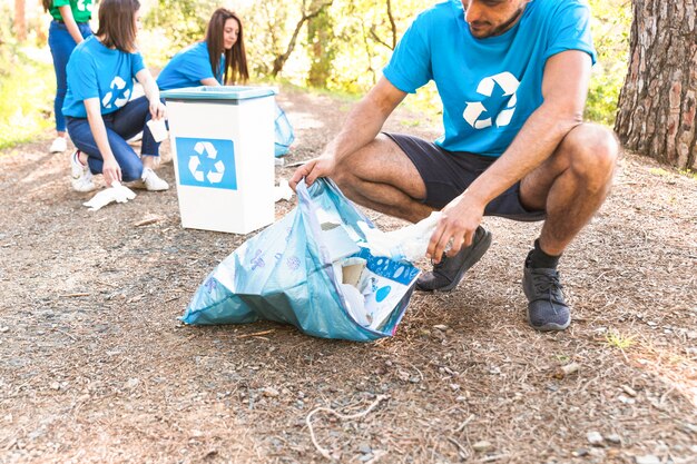 Volunteers collecting trash in forest 