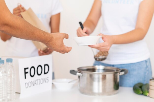 Volunteers handing bowl of food