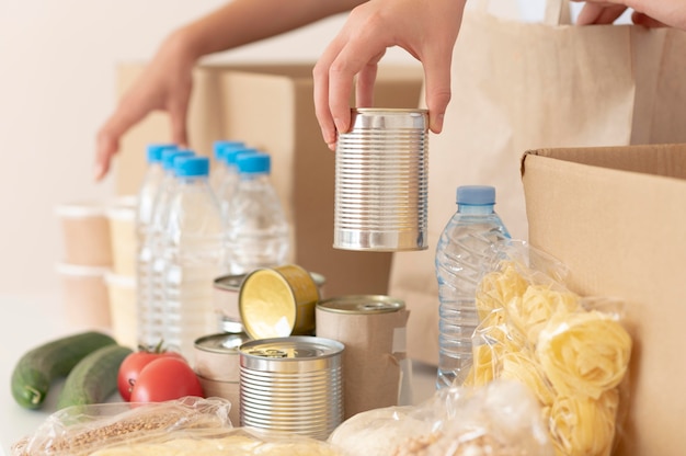 Volontari che mettono cibo in scatola per la donazione nella scatola