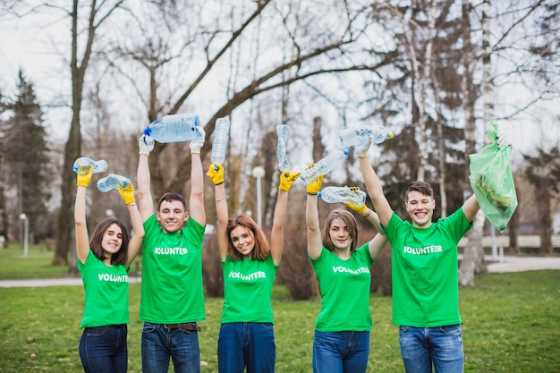 Free photo volunteers raising plastic bottles