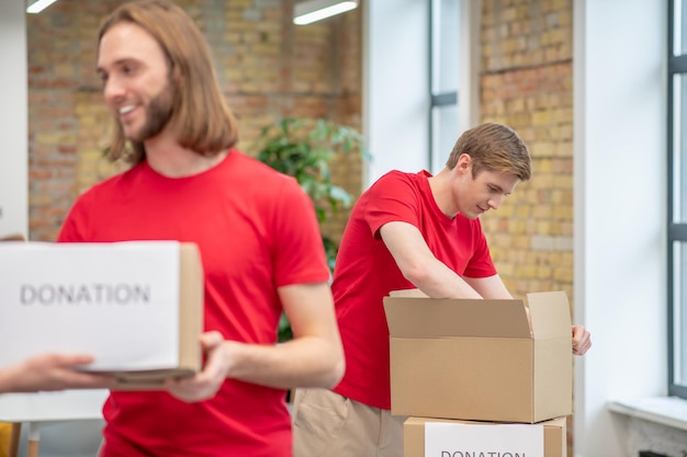 Foto gratuita volontari che lavorano in un punto di smistamento e sembrano occupati