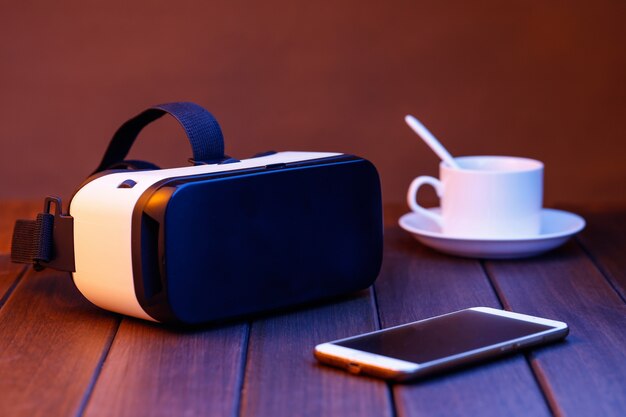 vr glasses and cell phone on wooden desk