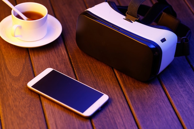 vr glasses and cell phone on wooden desk