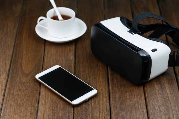 vr glasses and cell phone on wooden desk