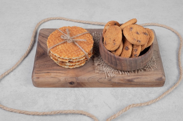 Waffle and bowl of cookies on white surface. high quality photo