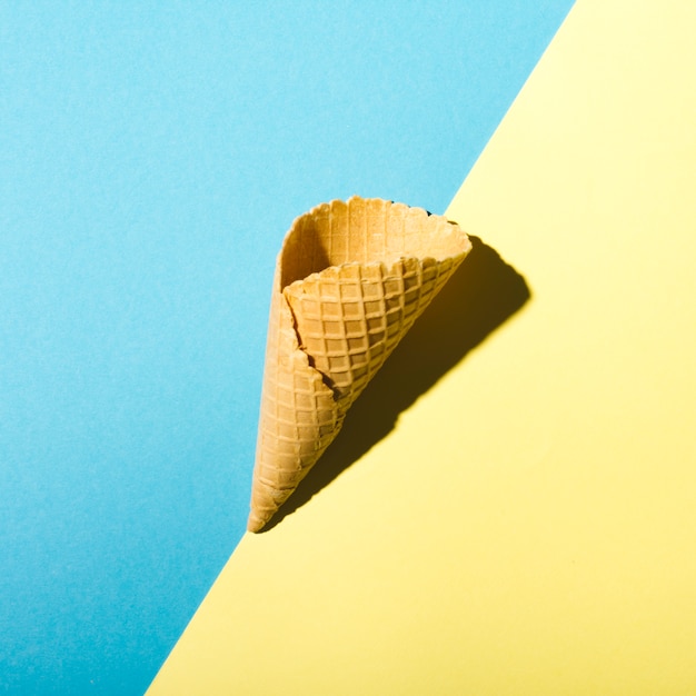 Waffle cone on blue and yellow background