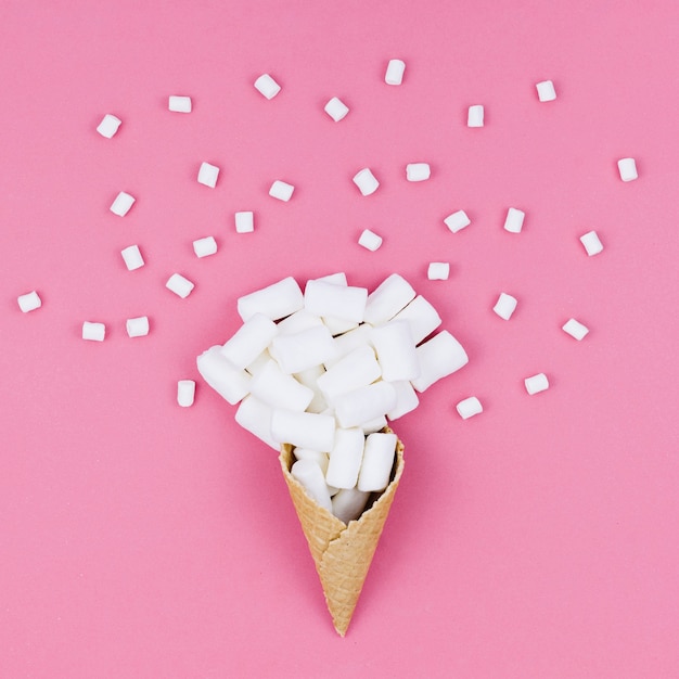 Waffle cone with marshmallows on table 