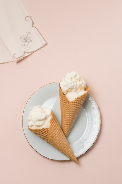 Free photo waffle cones with ice cream on plate near napkin