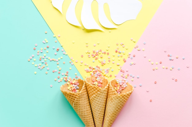 Waffle cones with sugar sprinkles and palm leaf 