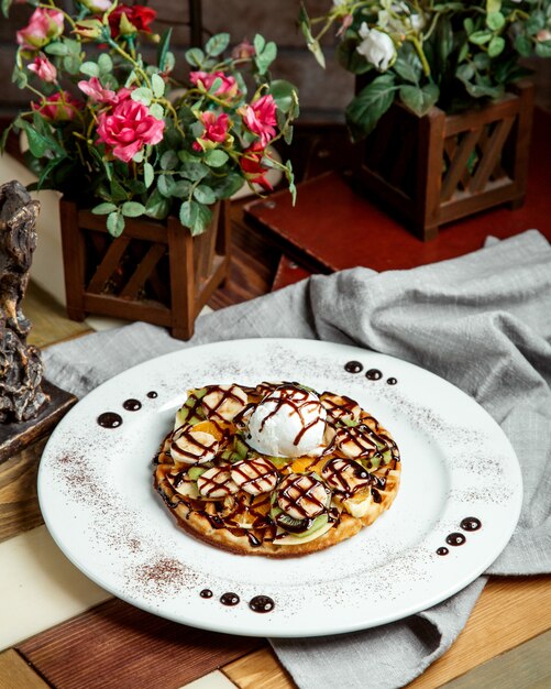 Waffle with fruits banana kiwifruit vanilla ice cream and chocolate sauce