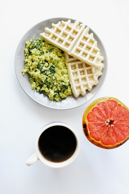 Waffle con pompelmo a fette sul piatto in ceramica bianca