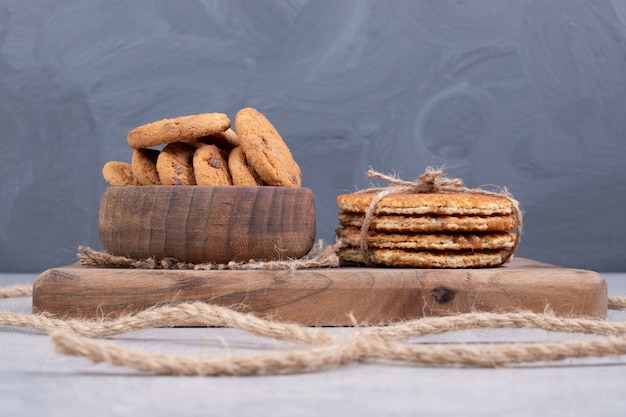 Waffles and bowl of cookies on white table. High quality photo
